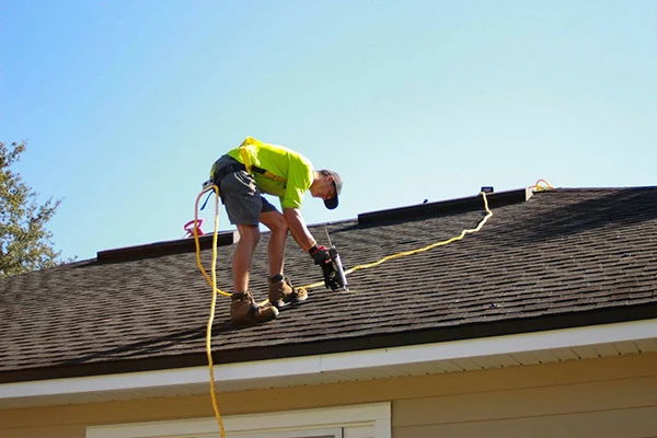man-working-on-a-roof-with-a-power-drill